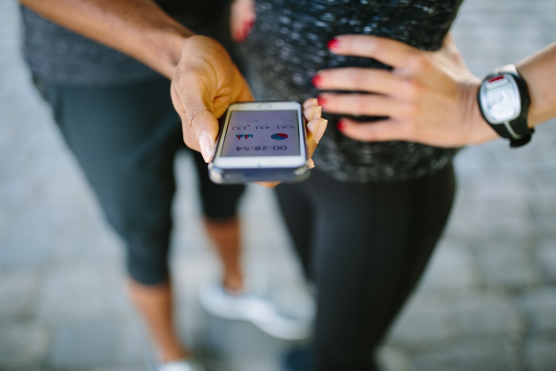 Young people checking their fitness progress on smartphone